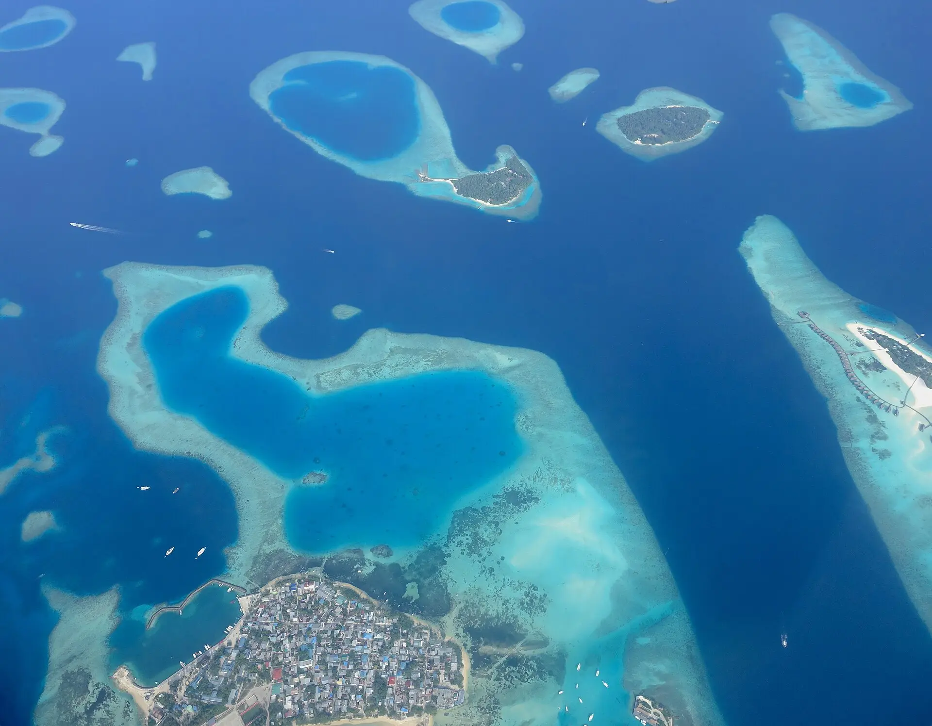Aerial view of densely built Guraidhoo and the surrounding reefs and lagoons of South Malé Atoll