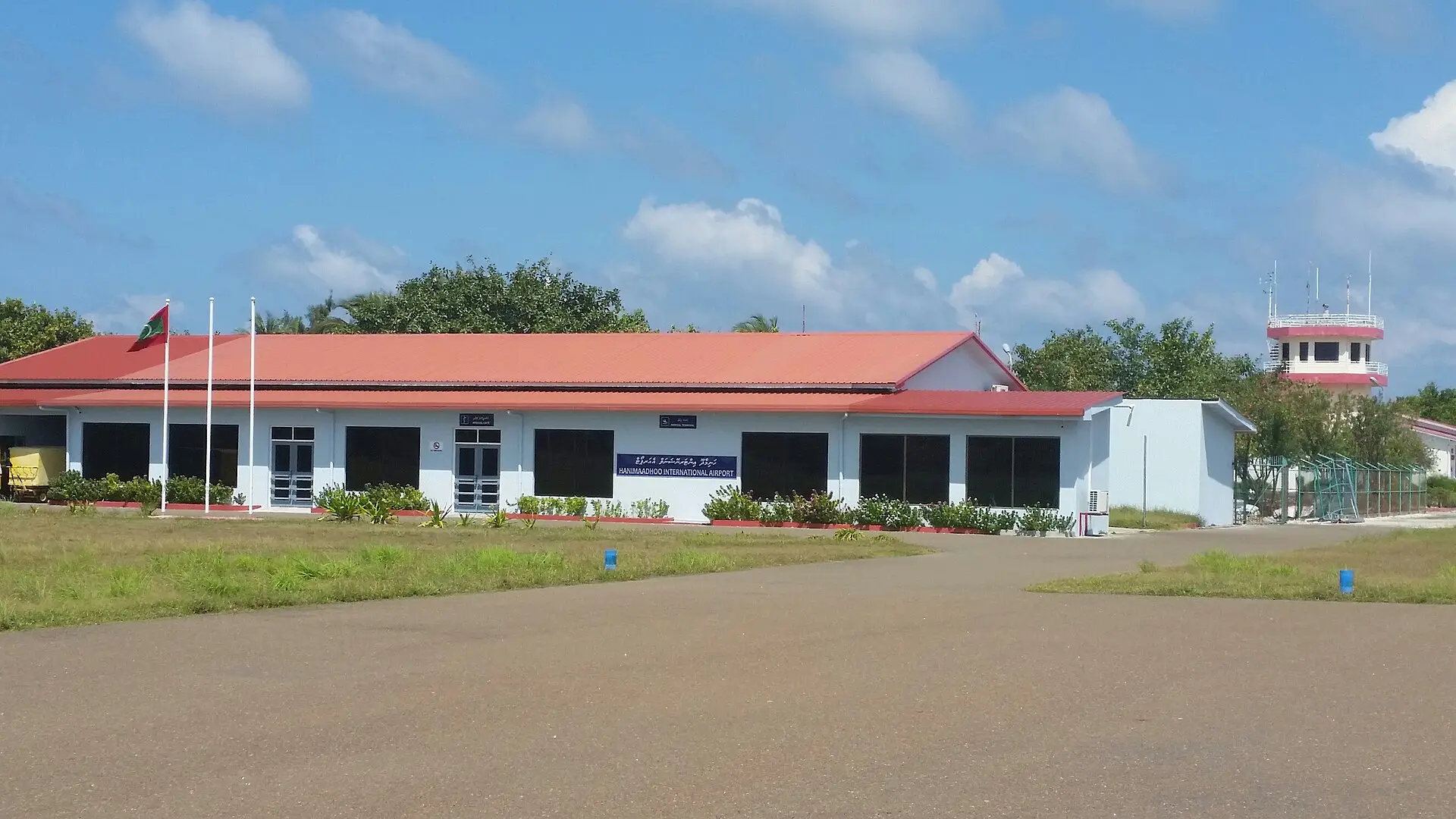 The red-roofed terminal building of Hanimaadhoo Airport with its control tower