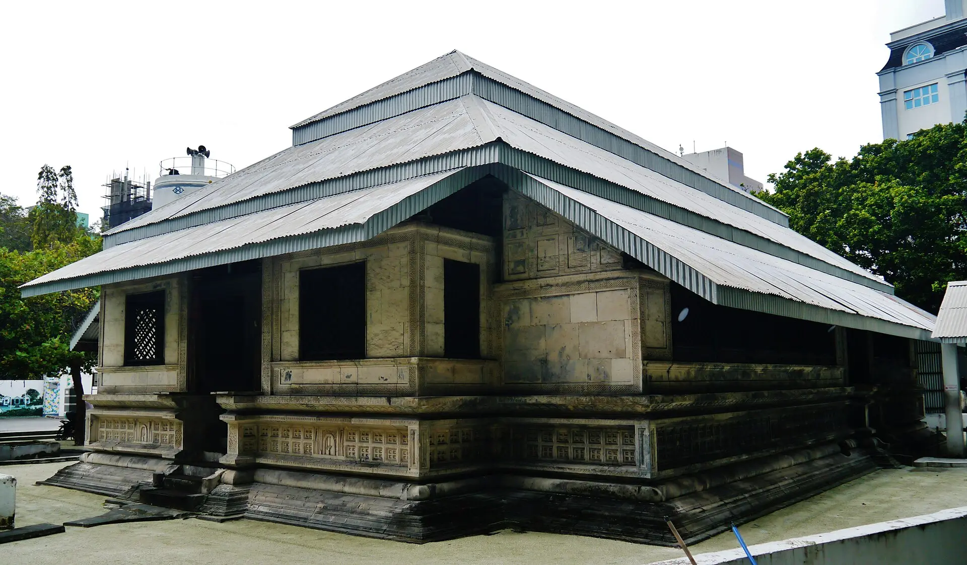 Exterior of the Malé Friday Mosque (Hukuru Miskiy), an old coral-stone building with a pitched metal roof