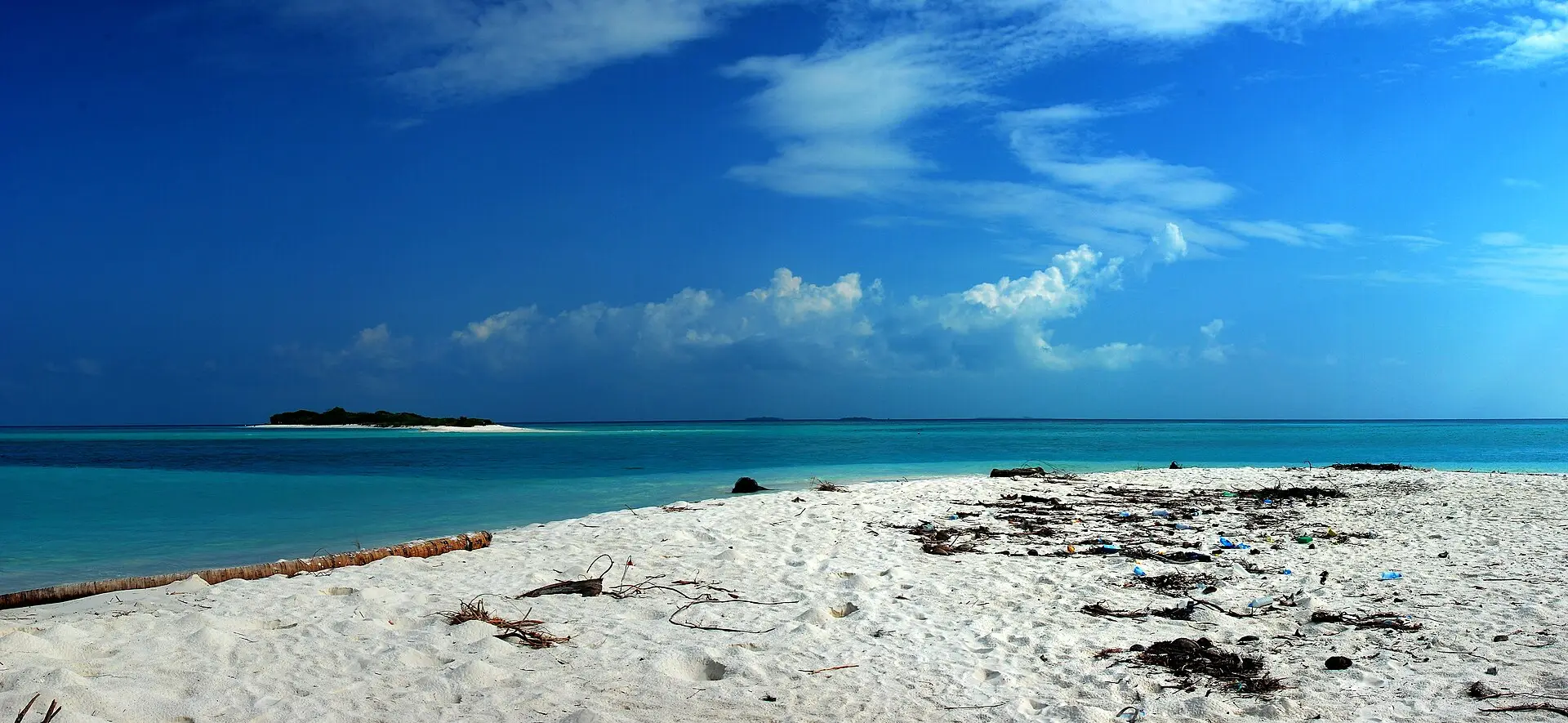 A white sand beach on Mathiveri looking out over turquoise water to a distant island